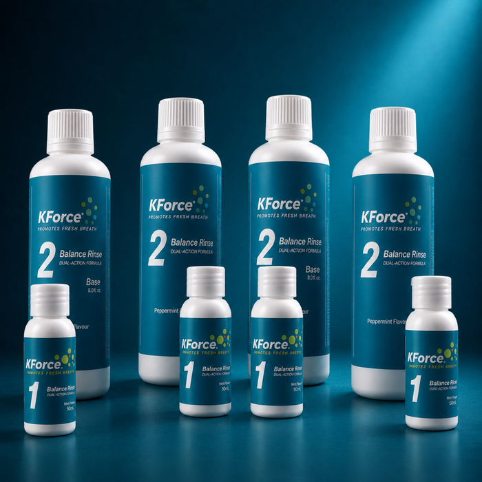 A set of KForce oral rinse bottles in two sizes, with larger white bottles labeled '2 Balance Rinse' and smaller white bottles labeled '1 Balance Rinse', arranged on a dark blue gradient background.